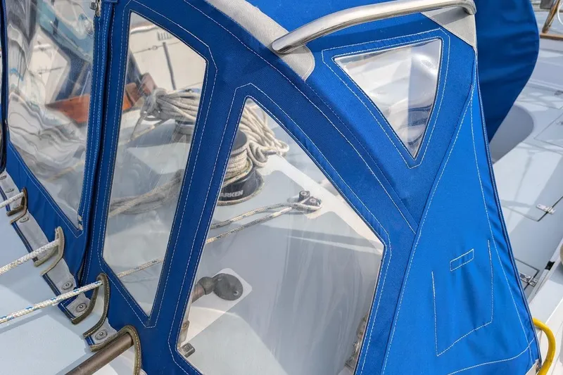 Slide: The Image of 1980 Island Trader 38 sailboat with blue canvas cover and visible rigging details. - 25