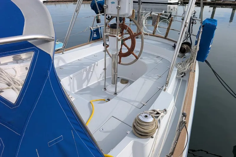 Slide: The Image of 1980 Island Trader 38 sailboat deck with blue canvas, wooden wheel, and mooring lines. - 26