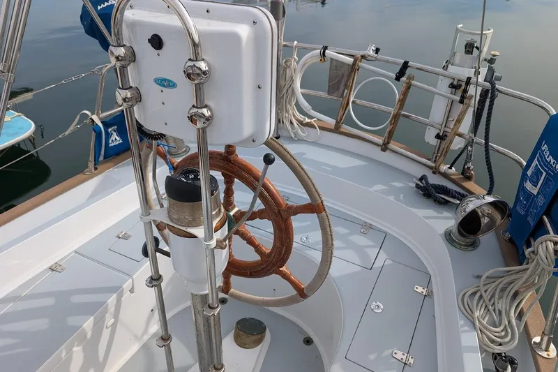 Slide: The Image of 1980 Island Trader 38 sailboat helm with wooden wheel and nautical equipment. - 27