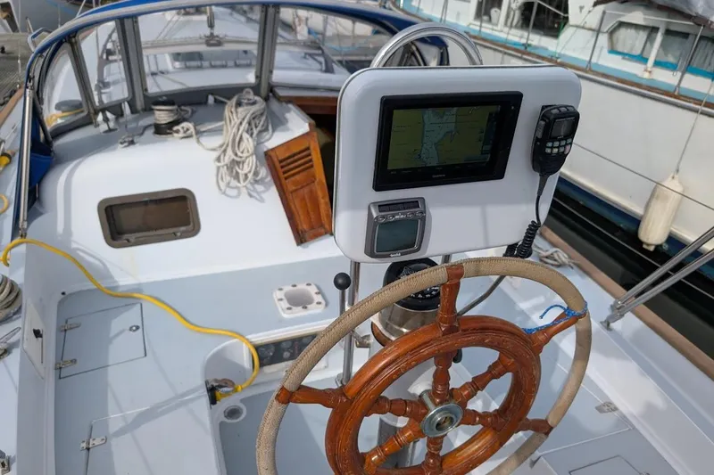 Slide: The Image of 1980 Island Trader 38 sailboat cockpit with wooden wheel and navigation equipment. - 28