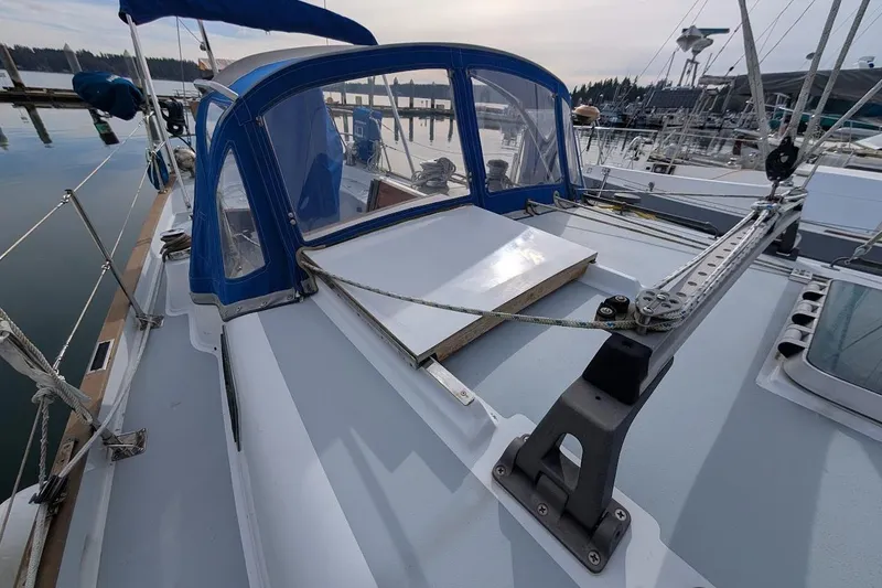 Slide: The Image of 1980 Island Trader 38 sailboat deck with blue canopy, docked at marina. - 33
