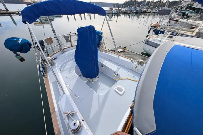 Slide: The Image of 1980 Island Trader 38 sailboat with blue covers docked at a marina. - 34