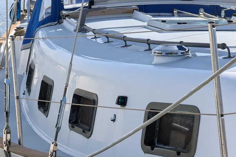 Slide: The Image of 1980 Island Trader 37 sailboat deck with windows and railing, docked by the water. - 35