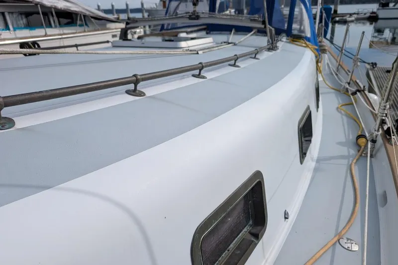 Slide: The Image of 1980 Island Trader 38 sailboat deck with railings and windows in a marina. - 36