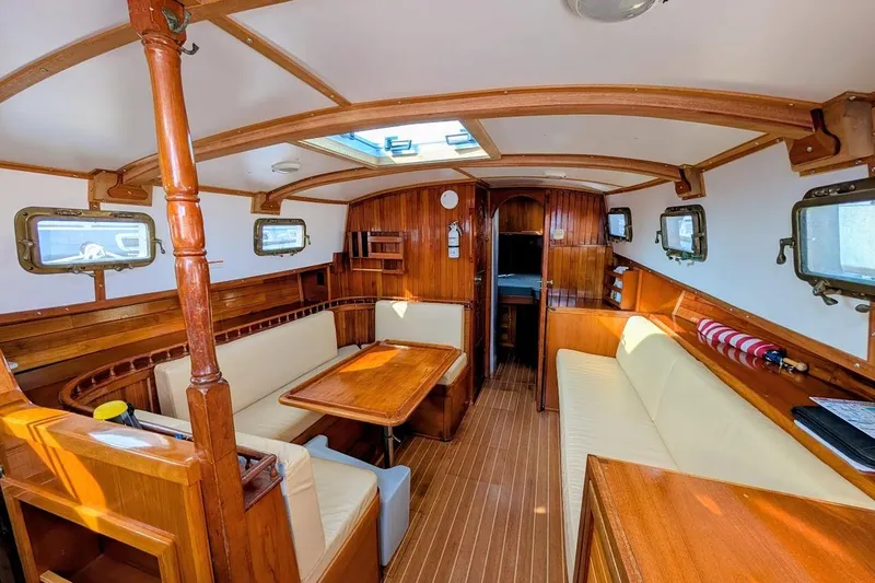 Slide: The Image of Interior of 1980 Island Trader 38 sailboat with wooden furnishings and cozy seating area. - 7