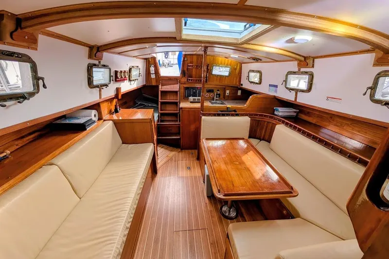 Slide: The Image of Interior of 1980 Island Trader 38 sailboat with wooden furnishings and beige seating. - 8
