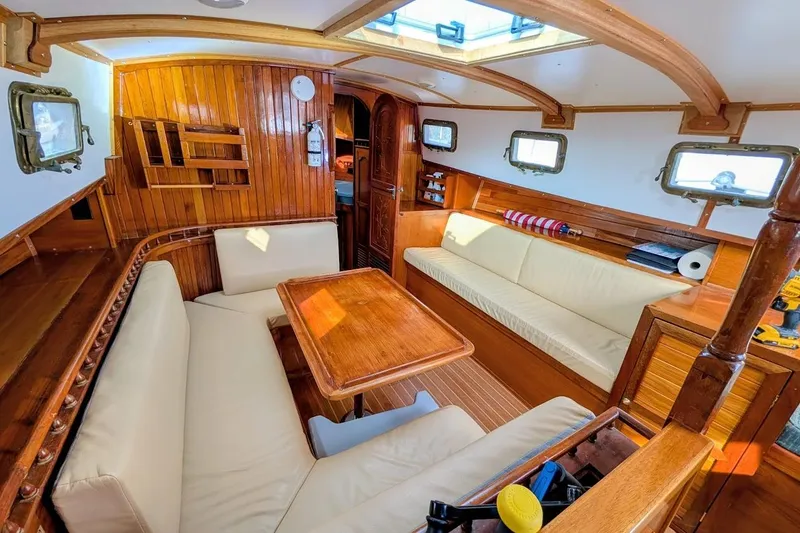 Slide: The Image of Interior of 1980 Island Trader 38 sailboat with wooden paneling and cozy seating area. - 9