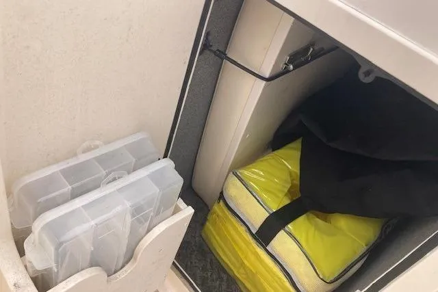 Slide: The Image of Storage compartment in a 2023 Grady-White Freedom 215 boat with organized gear. - 14
