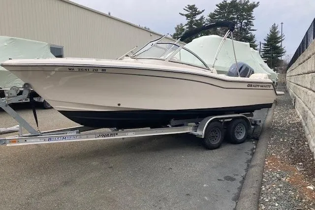 Slide: The Image of 2023 Grady-White Freedom 215 boat on trailer, parked outdoors near a building. - 3