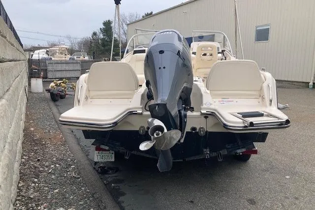 Slide: The Image of 2023 Grady-White Freedom 215 boat with outboard motor, parked outdoors near a building. - 4