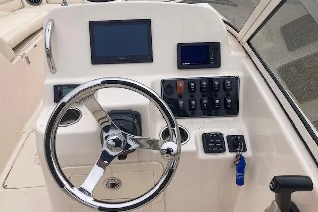 Slide: The Image of 2023 Grady-White Freedom 215 boat dashboard with steering wheel and control panel. - 9
