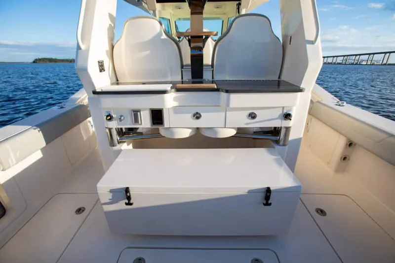 Slide: The Image of Manufacturer Provided Image: 2025 Scout 425 LXF boat interior with seating and storage, on calm water. - 8