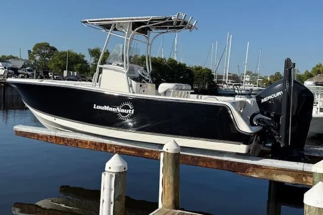 The Image of 2019 Mako 214 Center Console boat docked, featuring sleek design and Mercury engine. - 0
