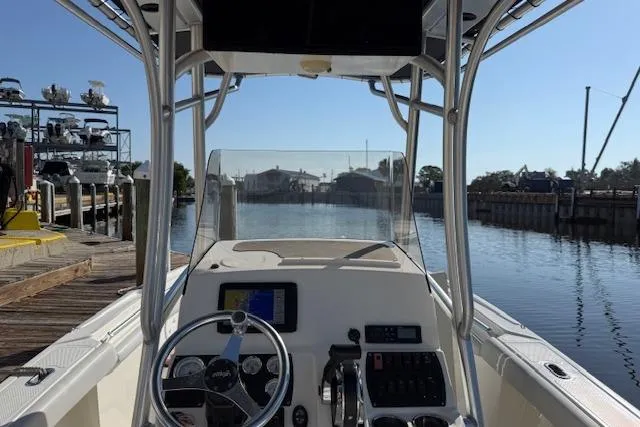 Slide: The Image of 2019 Mako 214 Center Console boat docked, featuring steering wheel and control panel. - 10