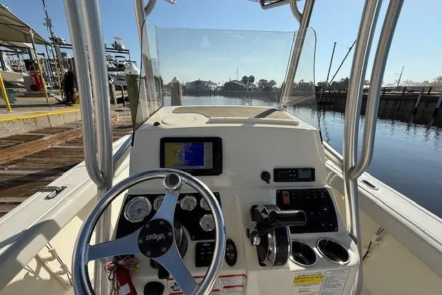 Slide: The Image of 2019 Mako 214 Center Console boat dashboard with steering wheel and navigation equipment. - 11