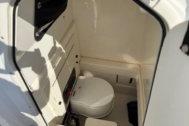 Slide: The Image of 2019 Mako 214 Center Console boat interior with compact marine toilet. - 17