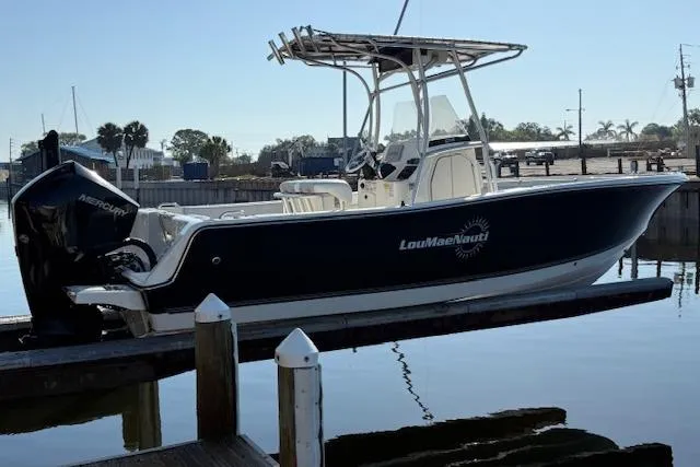 Slide: The Image of 2019 Mako 214 Center Console boat docked, featuring a Mercury engine. - 2