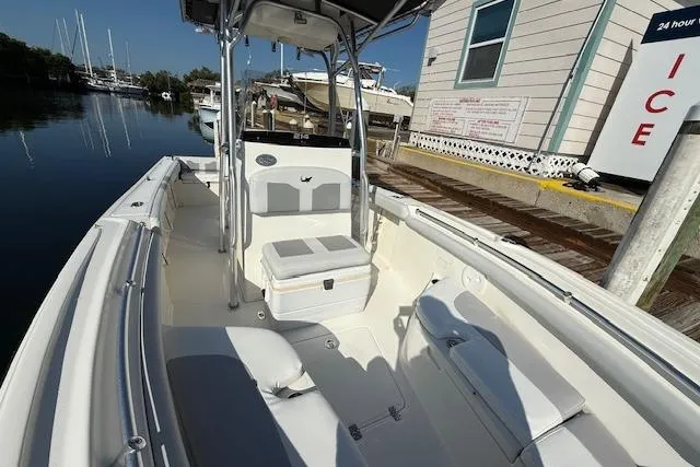 Slide: The Image of 2019 Mako 214 Center Console boat docked at marina, featuring spacious seating and storage. - 22