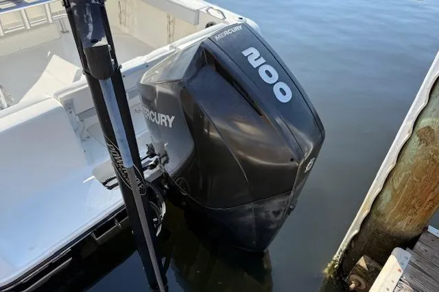 Slide: The Image of 2019 Mako 214 Center Console with Mercury 200 outboard engine docked by water. - 6