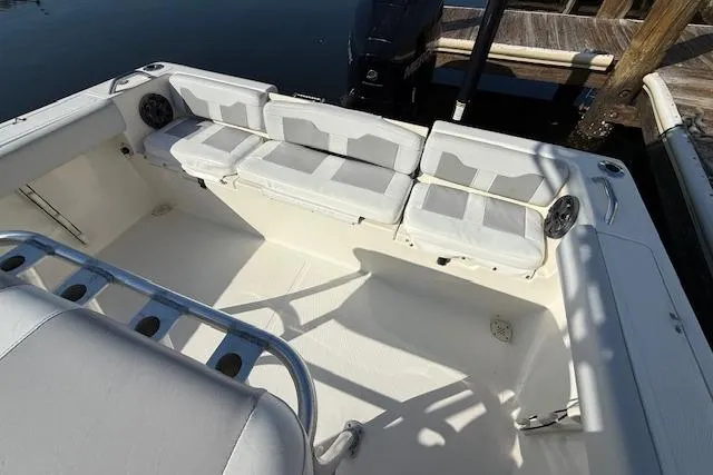 Slide: The Image of 2019 Mako 214 Center Console boat interior with cushioned seating and rod holders. - 8