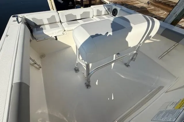 Slide: The Image of 2019 Mako 214 Center Console boat interior with seating and console, docked by the water. - 9