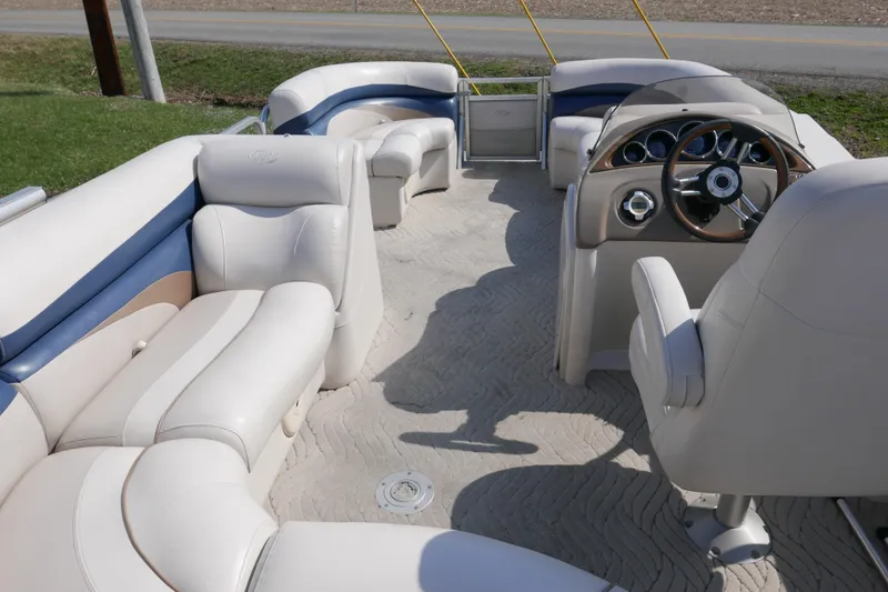 Slide: The Image of Interior of a 2009 Manitou 20 Encore pontoon boat with plush seating and steering console. - 11