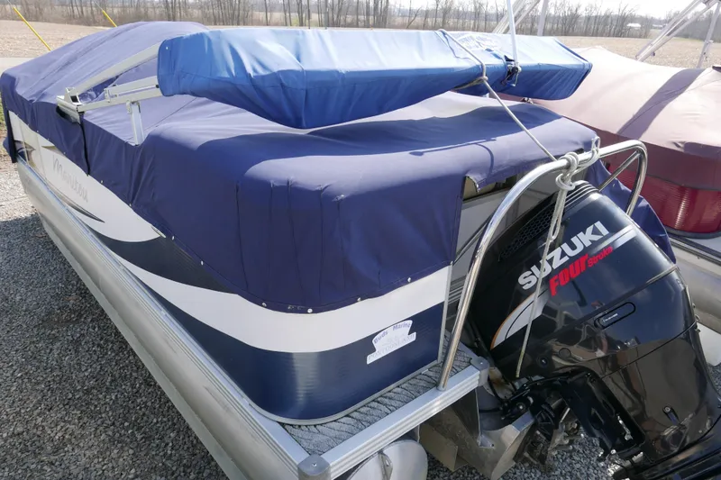 Slide: The Image of 2009 Manitou 20 Encore pontoon boat with Suzuki Four Stroke engine, covered and parked. - 15
