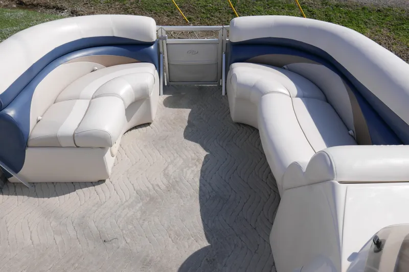 Slide: The Image of Interior seating of a 2009 Manitou 20 Encore pontoon boat with white and blue upholstery. - 4