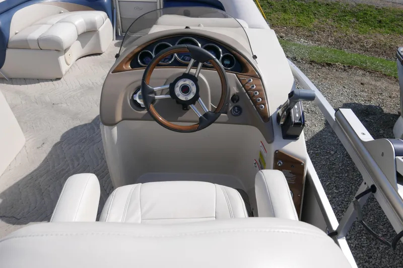 Slide: The Image of 2009 Manitou 20 Encore boat interior with steering wheel and control panel. - 9
