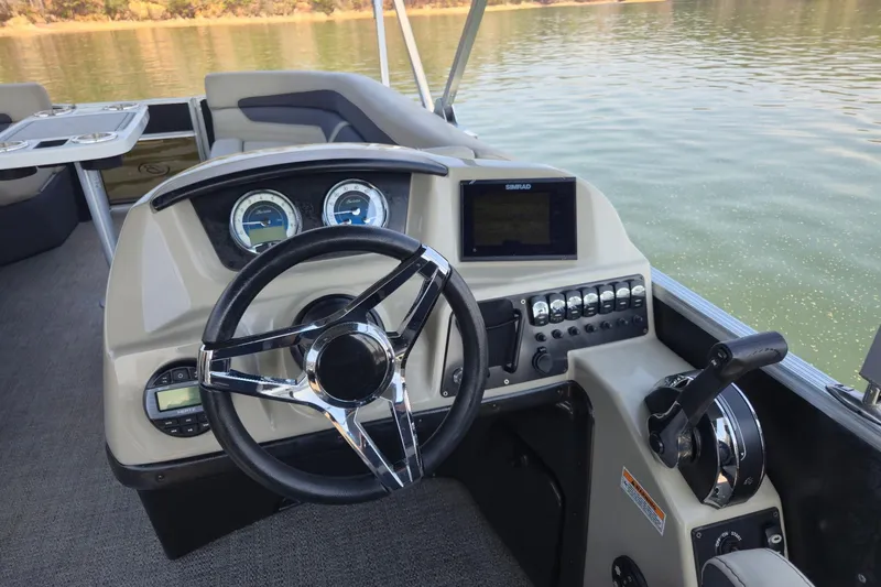 Slide: The Image of 2022 Barletta Cabrio 24UC boat dashboard with steering wheel and control panel. - 10