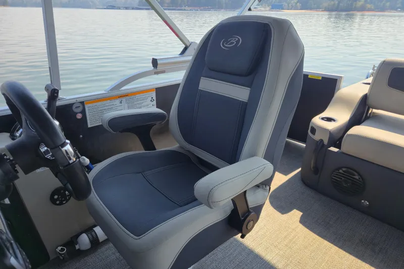 Slide: The Image of 2022 Barletta Cabrio 24UC boat interior with captain's chair and steering wheel. - 11