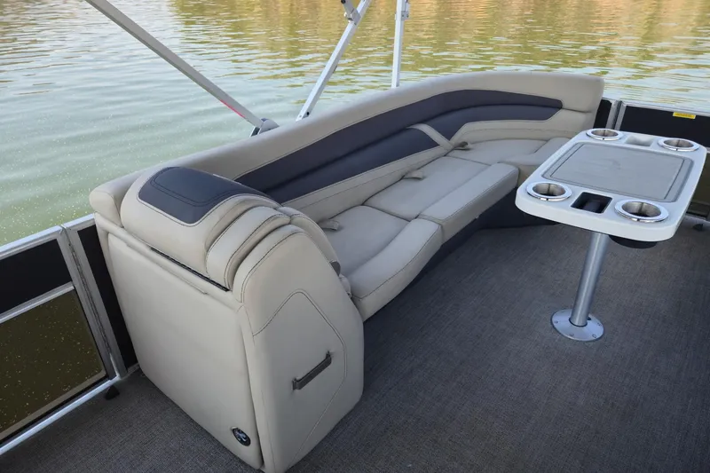 Slide: The Image of 2022 Barletta Cabrio 24UC pontoon boat interior with plush seating and table. - 14