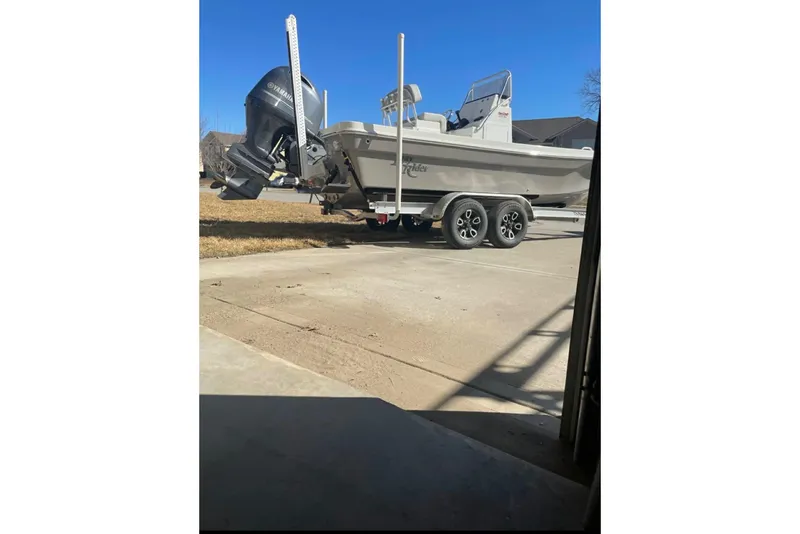 Slide: The Image of 2022 BayRider Kencraft 219 Bay boat on trailer, parked outdoors under clear blue sky. - 32