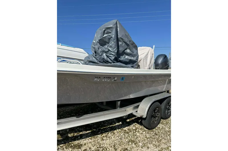 Slide: The Image of 2022 BayRider Kencraft 219 Bay boat on trailer, covered and parked outdoors. - 9