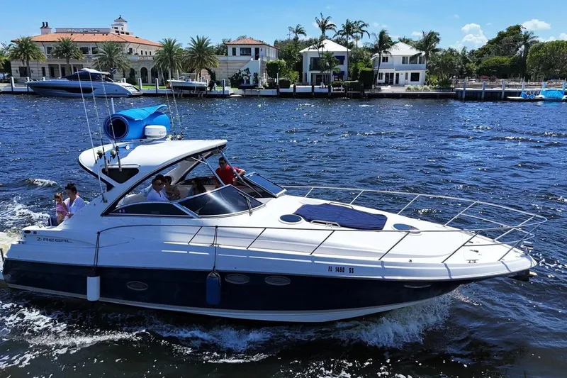 Slide: The Image of 2008 Regal 38 Express yacht cruising on a sunny day near waterfront homes. - 5