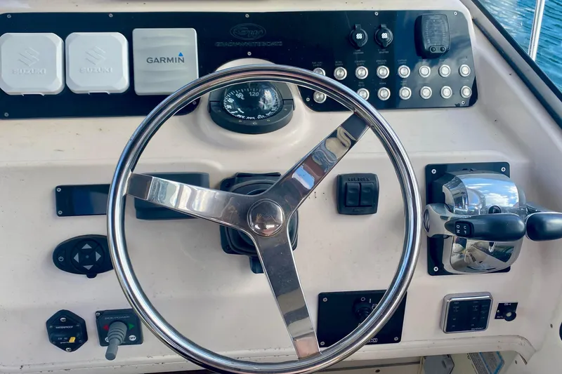 Slide: The Image of Steering console of a 2007 Grady-White Marlin 300 boat with Garmin and Suzuki controls. - 6