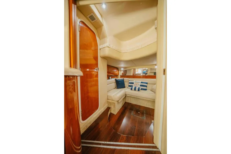 Slide: The Image of Interior of 2003 Sea Ray 420 Sundancer yacht with plush seating and wooden finishes. - 14