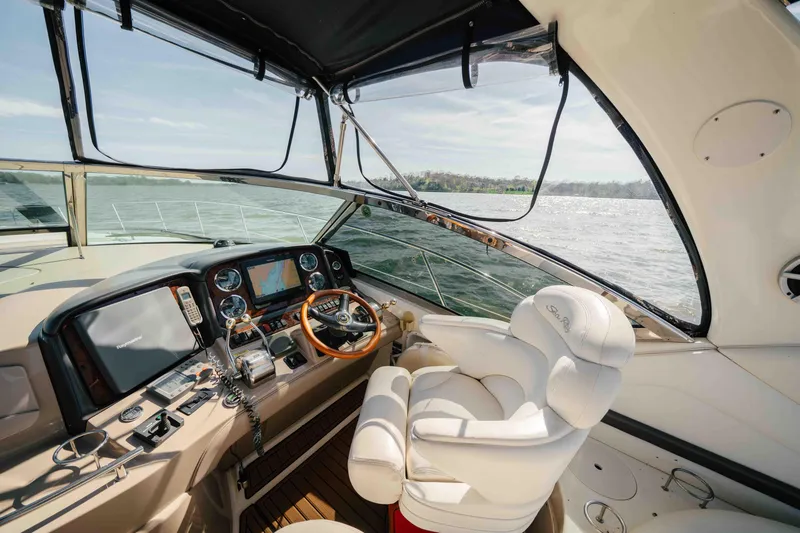 Slide: The Image of 2003 Sea Ray 420 Sundancer cruising on a calm lake under a clear blue sky. - 18