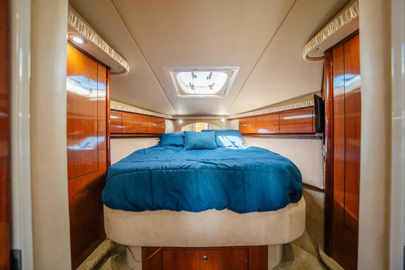 Slide: The Image of 2003 Sea Ray 420 Sundancer yacht cruising on a sunny lake with scenic shoreline. - 2