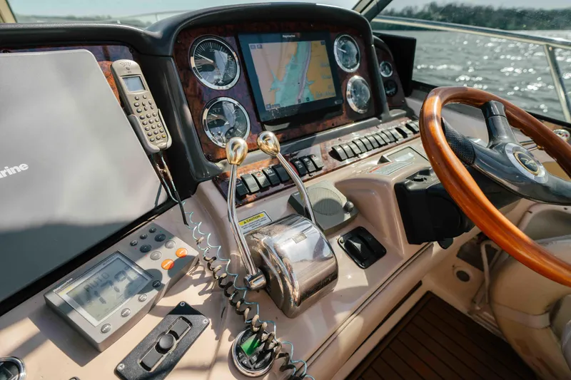 Slide: The Image of 2003 Sea Ray 420 Sundancer cruising on a calm lake under a clear blue sky. - 20