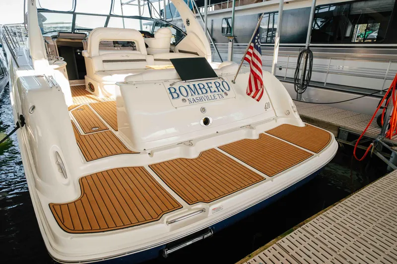 Slide: The Image of Cockpit of 2003 Sea Ray 420 Sundancer with navigation equipment and wooden steering wheel. - 24