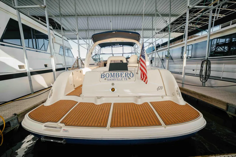Slide: The Image of Cockpit of 2003 Sea Ray 420 Sundancer with navigation equipment and wooden steering wheel. - 26
