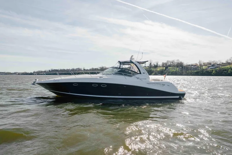 Slide: The Image of Cockpit of 2003 Sea Ray 420 Sundancer with navigation equipment and wooden steering wheel. - 27