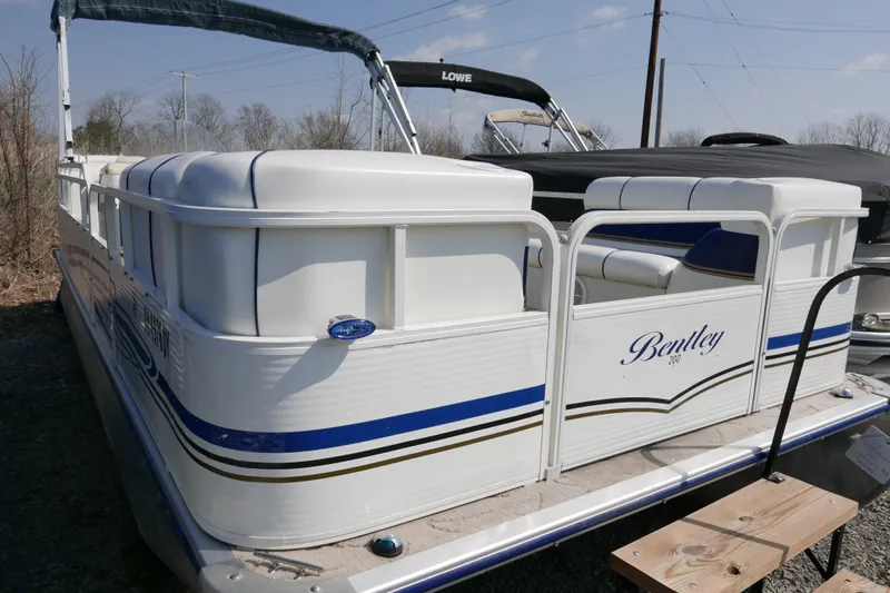 Slide: The Image of 2005 Bentley Pontoons 200 CRUISE boat with white and blue accents, docked outdoors. - 1
