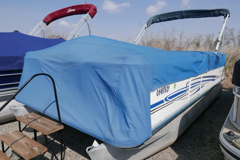 Slide: The Image of 2005 Bentley Pontoons 200 CRUISE boat with blue cover, parked outdoors. - 13