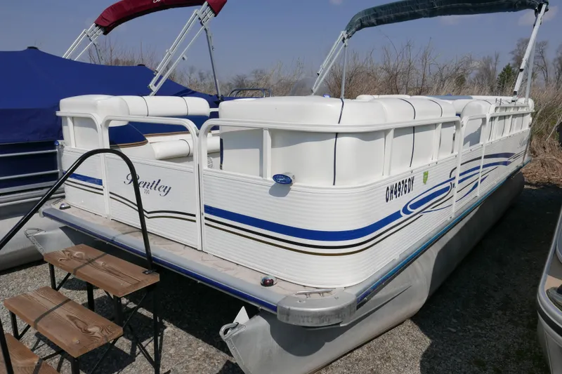 Slide: The Image of 2005 Bentley Pontoons 200 CRUISE boat with white and blue accents, docked outdoors. - 2