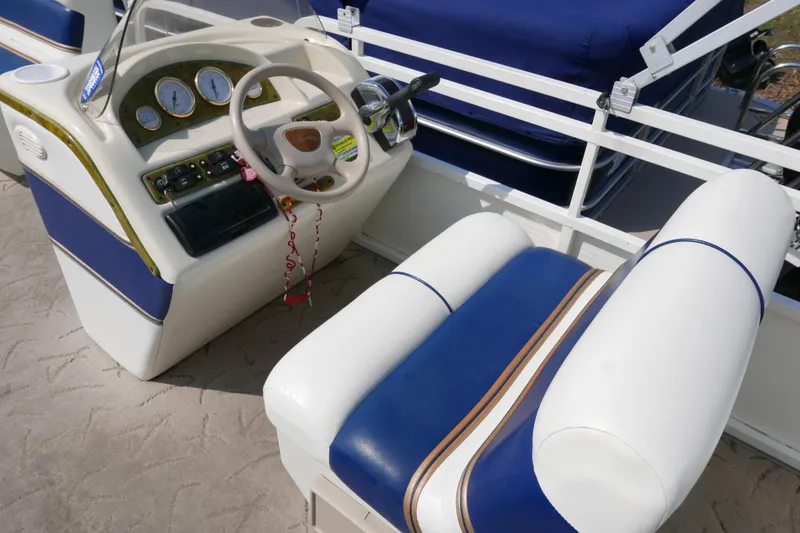 Slide: The Image of 2005 Bentley Pontoons 200 CRUISE helm with blue and white seating and dashboard controls. - 8