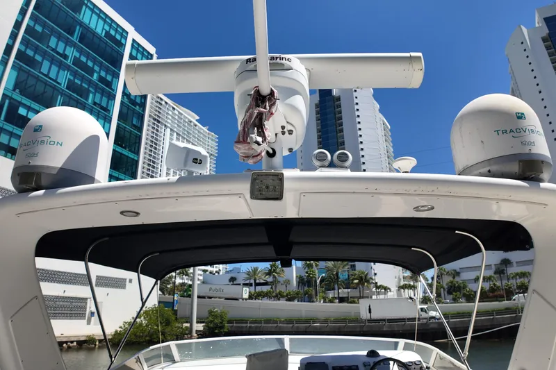 Slide: The Image of 2003 Navigator Rival boat with radar and TracVision domes, docked near modern buildings. - 12