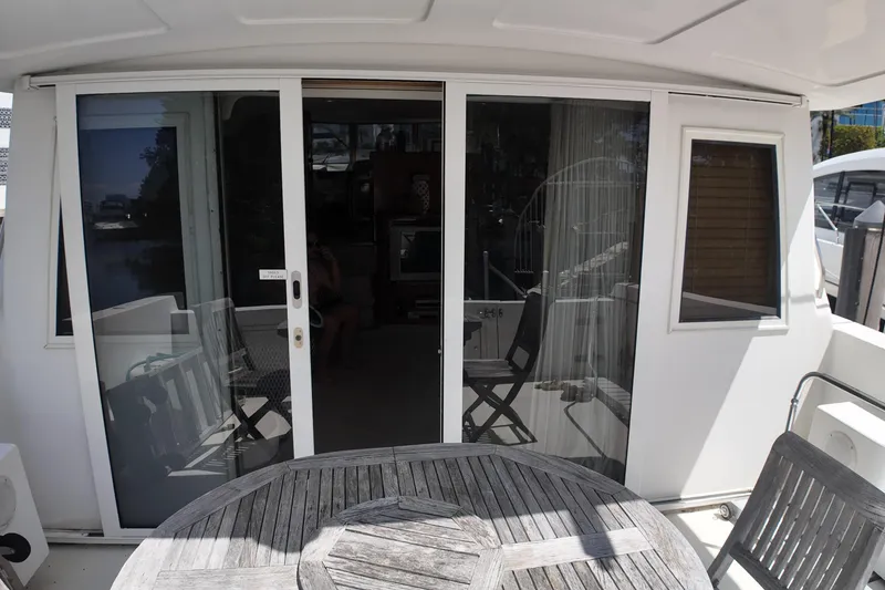 Slide: The Image of Sliding glass doors on 2003 Navigator Rival yacht with wooden deck furniture. - 13