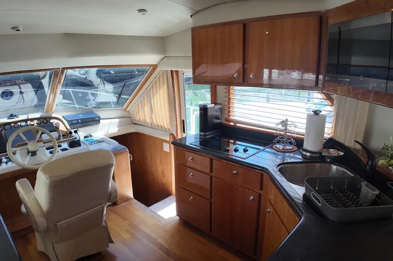 Slide: The Image of Interior of a 2003 Navigator Rival yacht featuring a helm and modern kitchen area. - 25